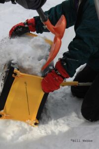 Shoveling snow into the ICEBOX Igloo Tool